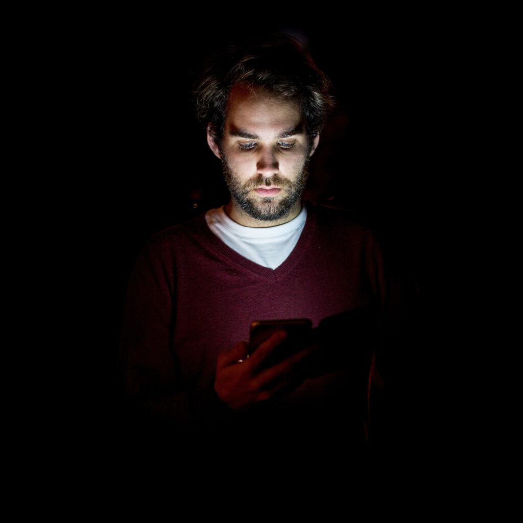 Man holding his phone in the dark